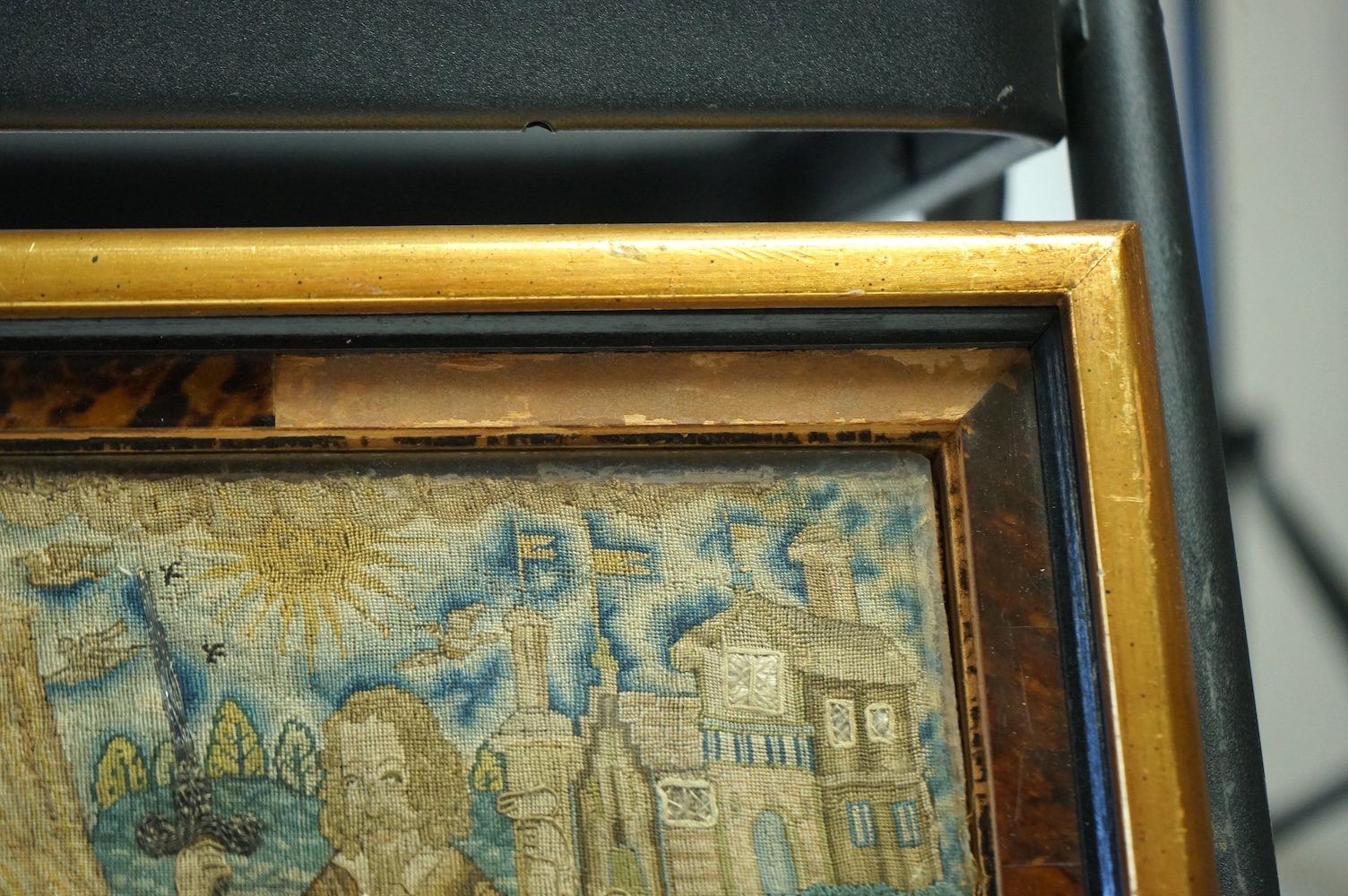 An 17th century petit point embroidered panel housed in a tortoise shell and gilt frame. The embroidery depicting Charles I, within a tent, with Henrietta Maria looking at a gentleman dangling a boy in one hand and sword